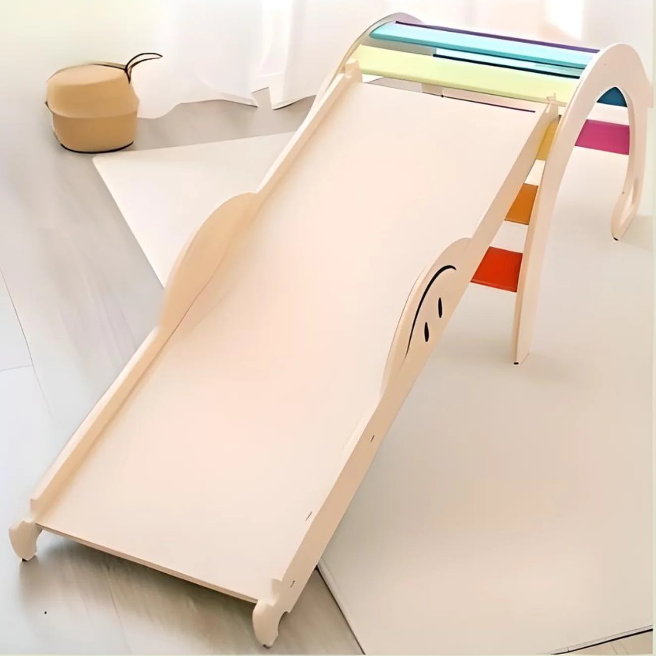 Kinderrutsche aus Holz mit einem regenbogenfarbigen Bogen an der Spitze.