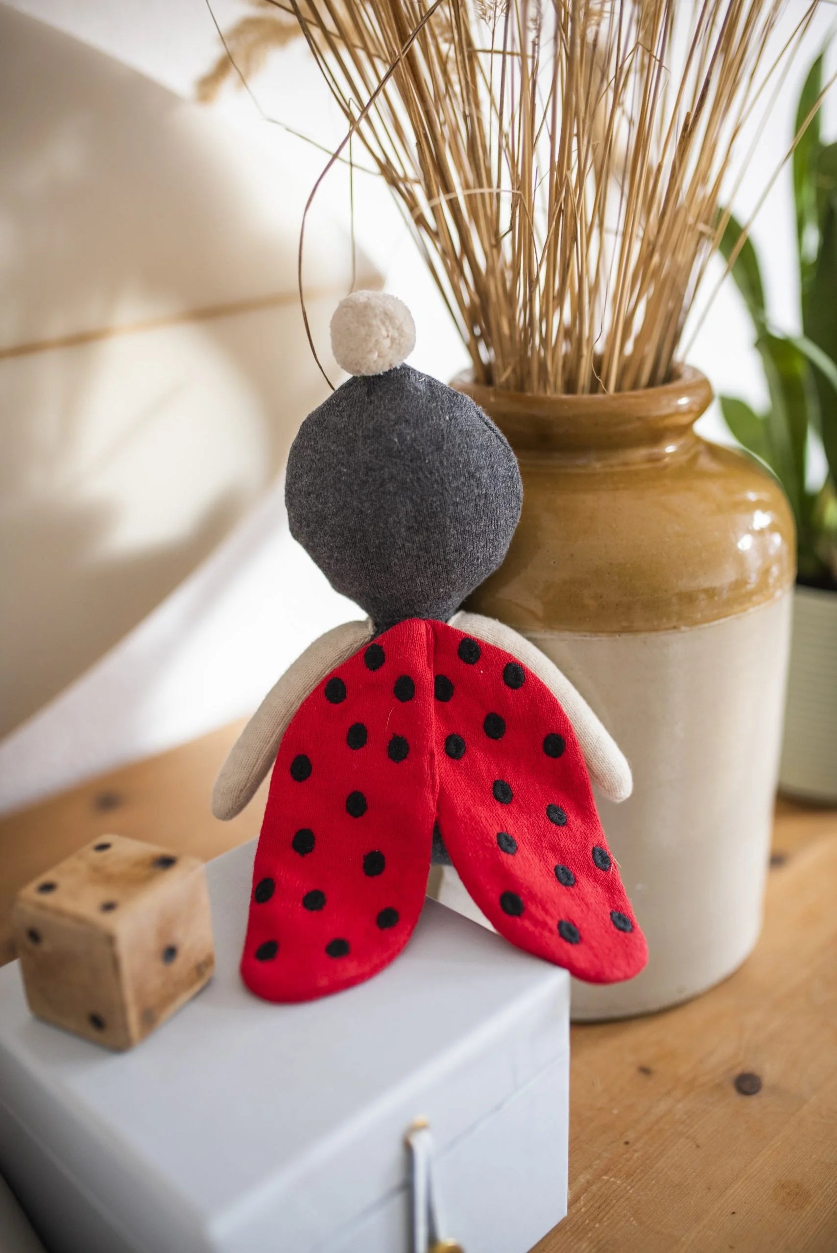 Dekoratives Marienkäfer-Ornament mit rot gepunkteten Flügeln und schwarzem Körper.