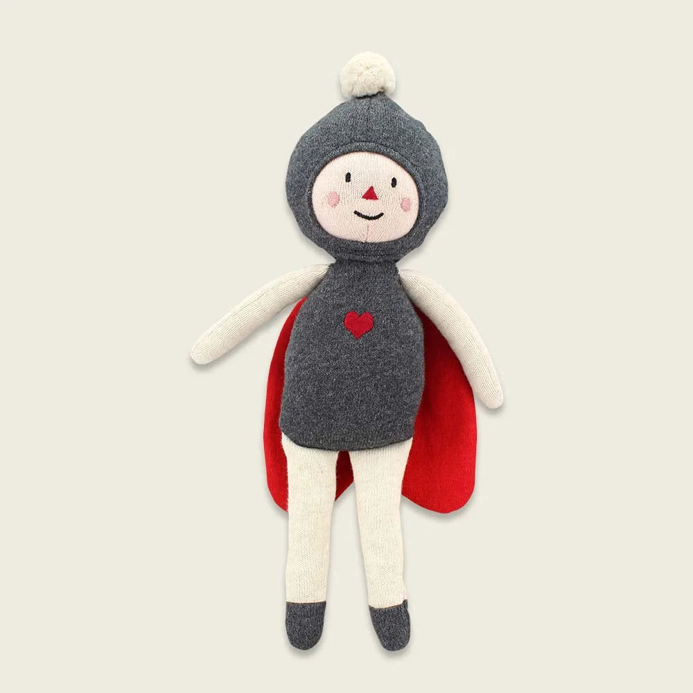 Plüschpuppe in grauem Kapuzen-Outfit mit rotem Umhang und einem Herz-Detail.