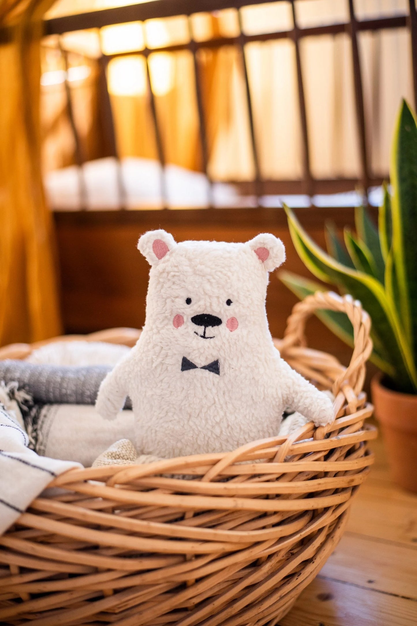 Weißer Plüsch-Teddybär mit schwarzer Fliege.
