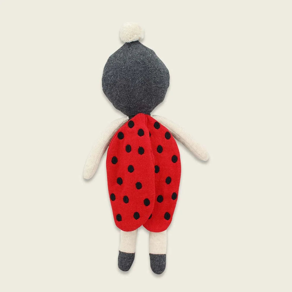 Handgefertigte Filzpuppe mit rotem Pünktchenkleid, grauen Haaren und Socken.