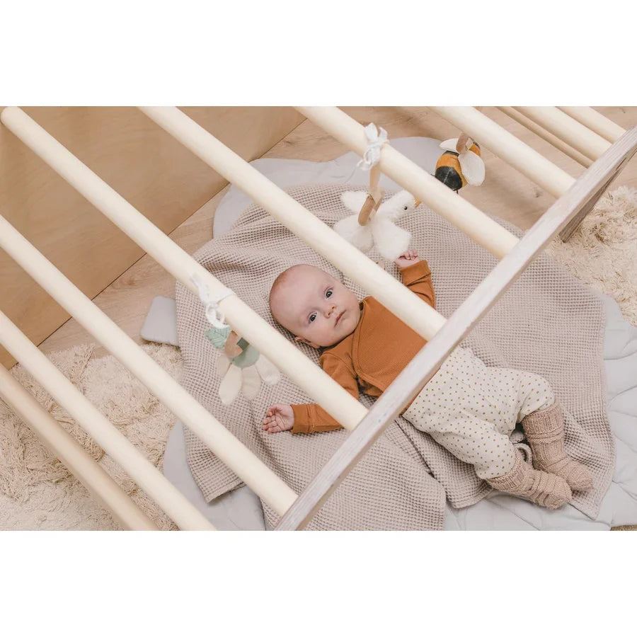 Baby im Kinderbett mit hängendem Spielzeug.